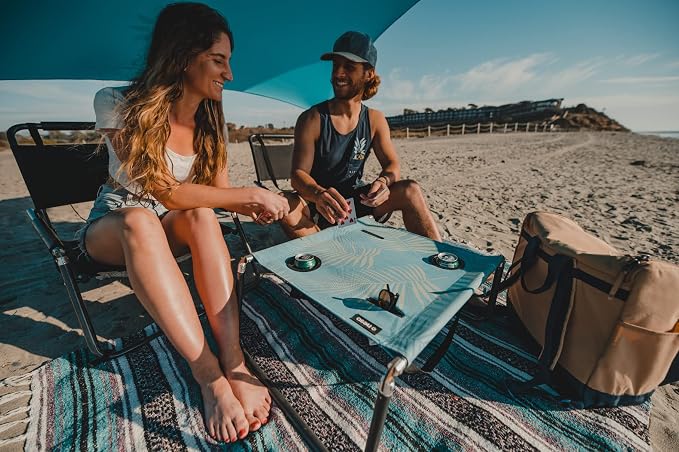 Neso Beach Table - Lightweight, Portable and Foldable Table for Beach, Camping and Outdoor Adventures - Stable Surface - with Cup Holder for Drinks and Phone Pockets - Aqua Fronds